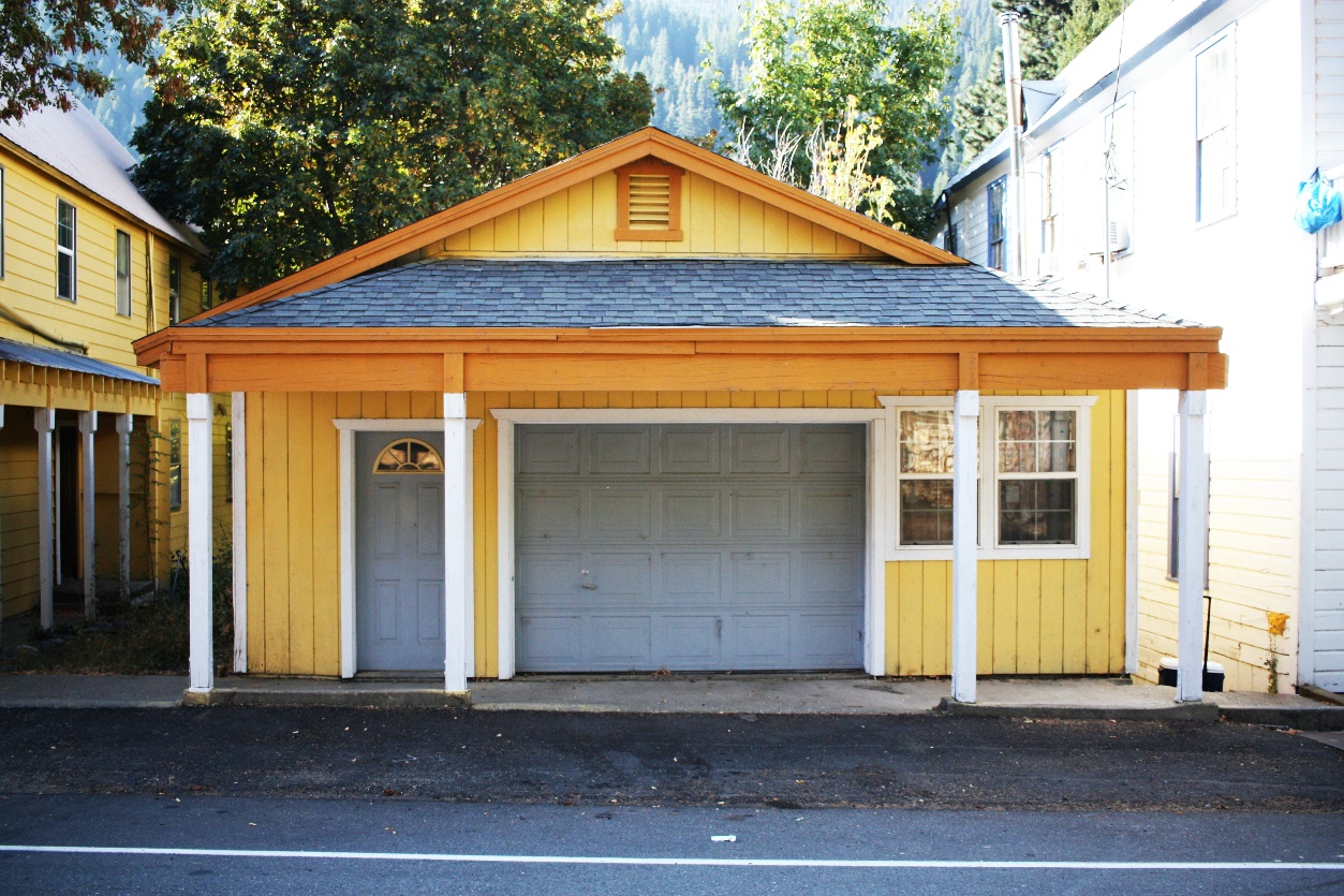 The view of a home garage from the front, with yellow walls and a white front