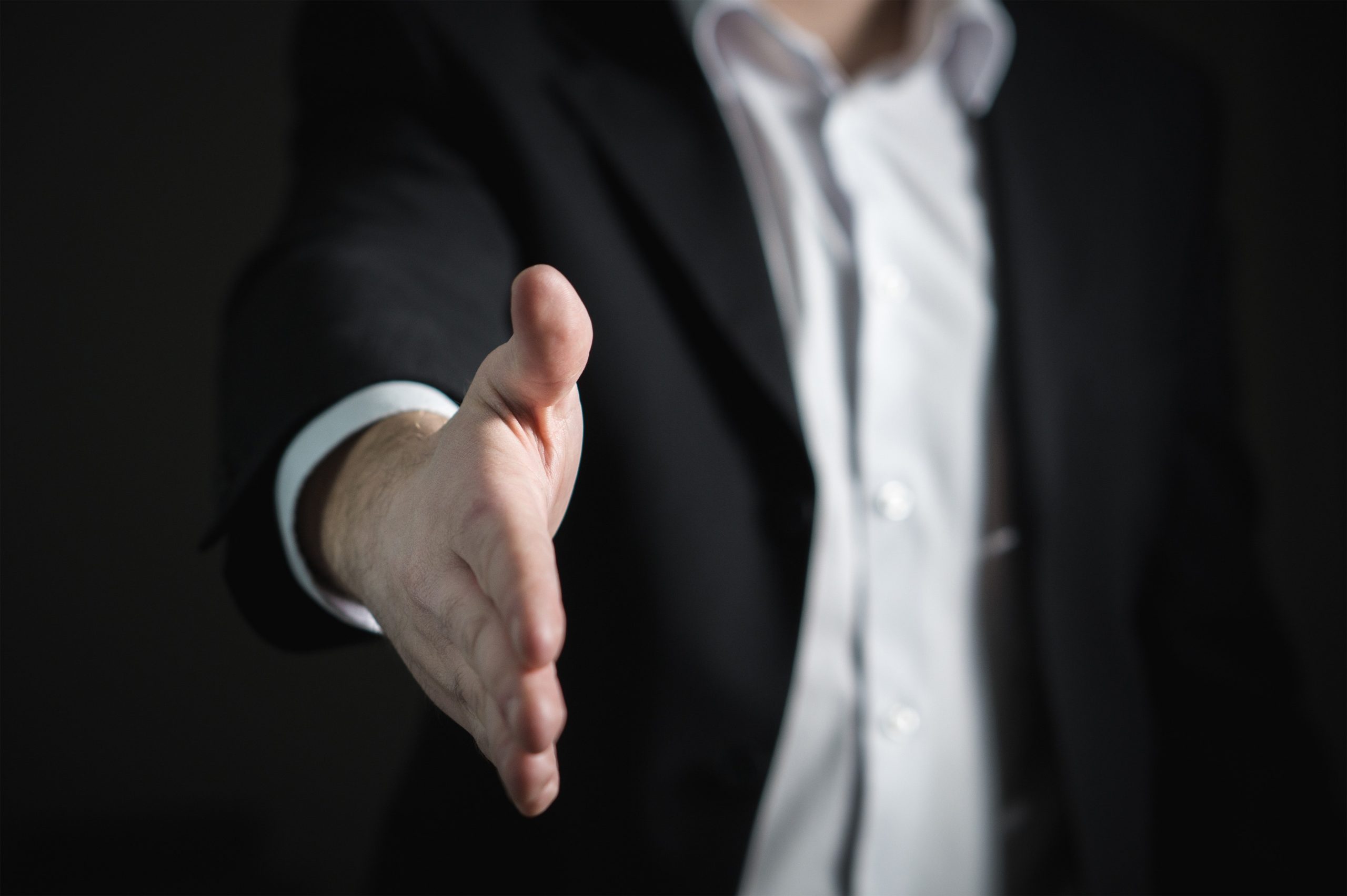 A person extending their hand out for a handshake