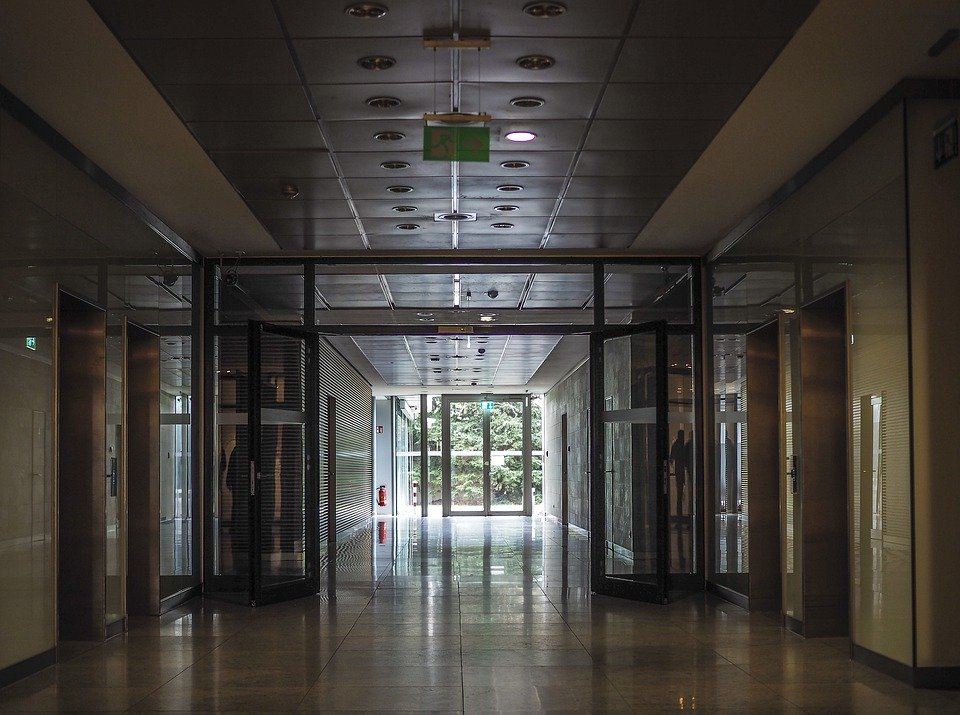 a corridor in a commercial space with multiple glass doors