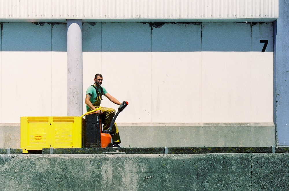 A warehouse worker sitting next to a dock leveler