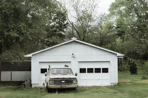 A car parked outside a garage with a new house garage door