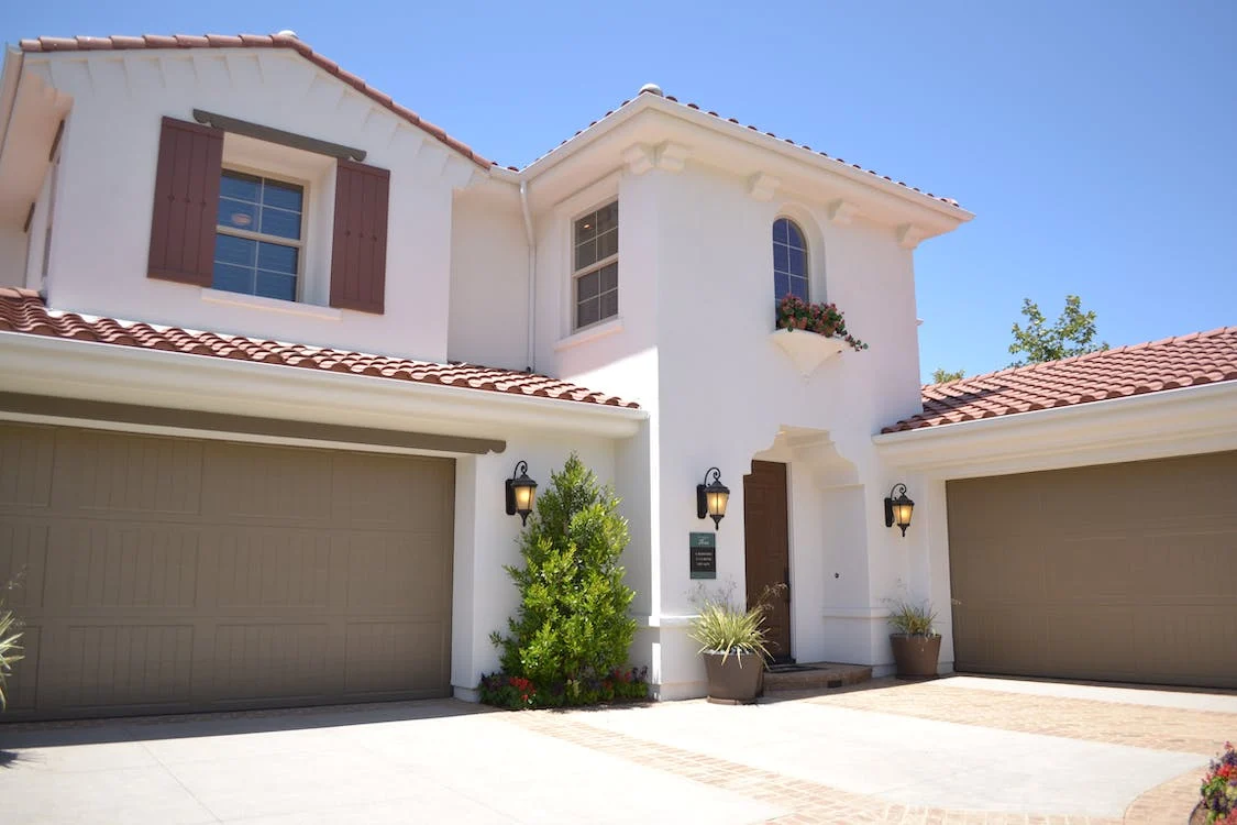 A white concrete house with a brown garage door