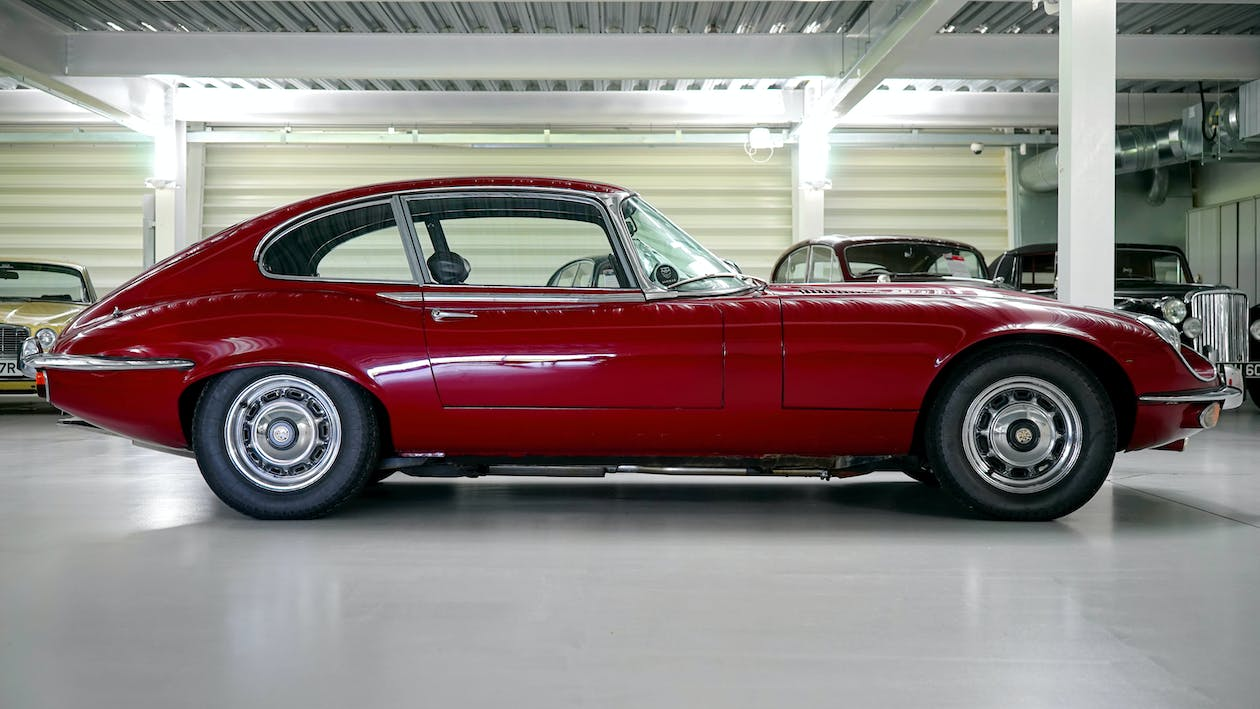 A classic car with a garage door in the background